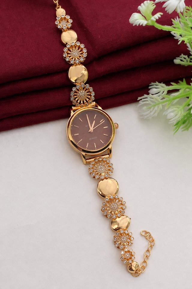 Elegant gold wristwatch on burgundy fabric